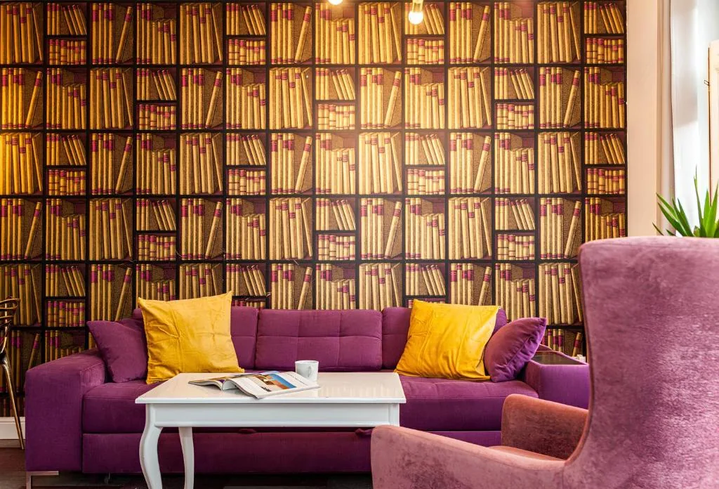Salon apartamentu Library z tapetą-regałem pełnym książek